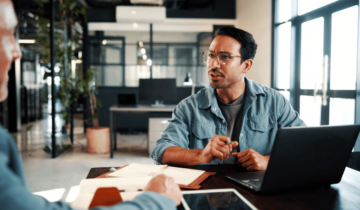 men talking laptop